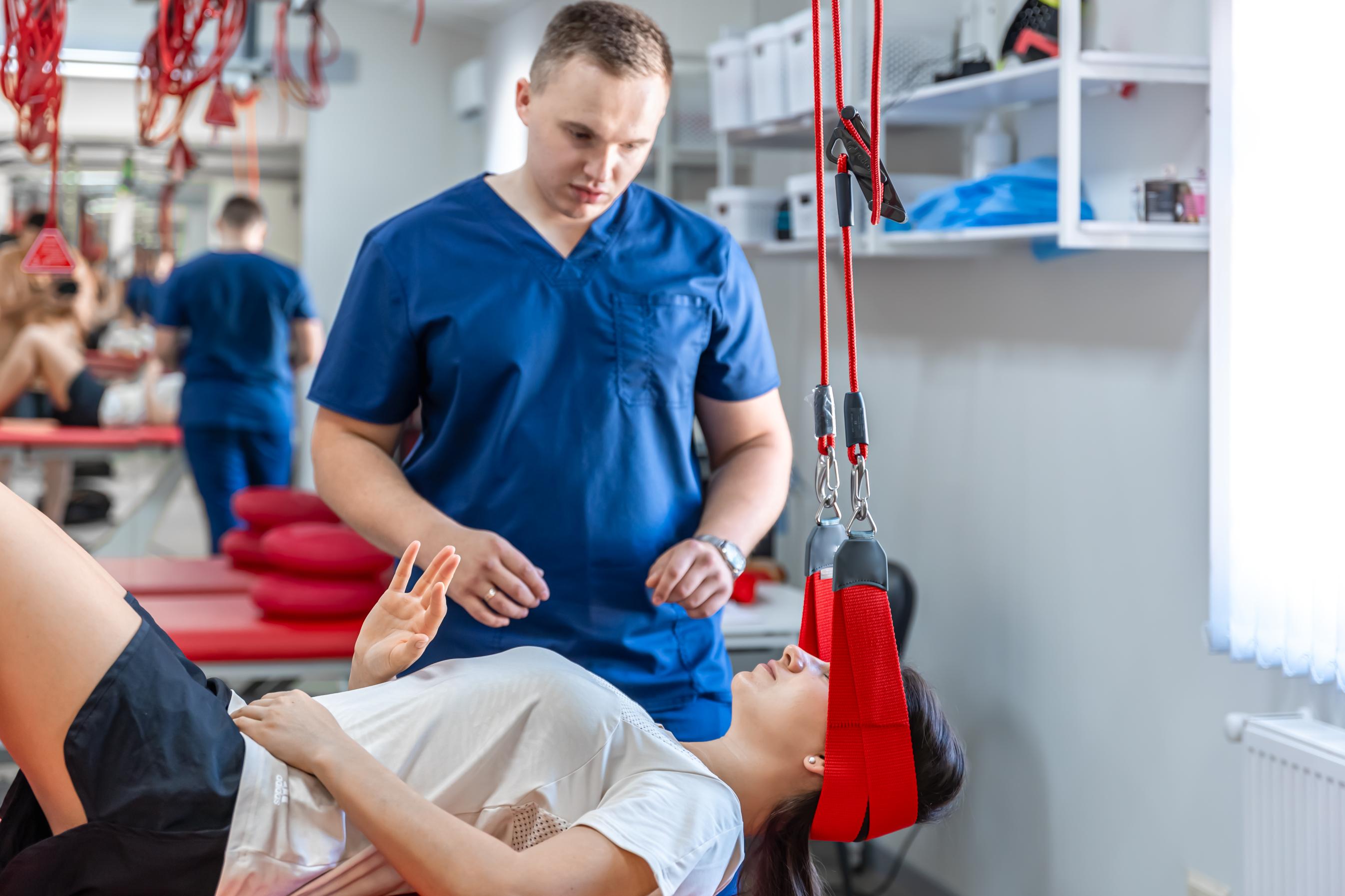 female-patient-hanging-on-suspensions-at-rehabilit-2023-11-27-05-07-04-utc (1).jpg